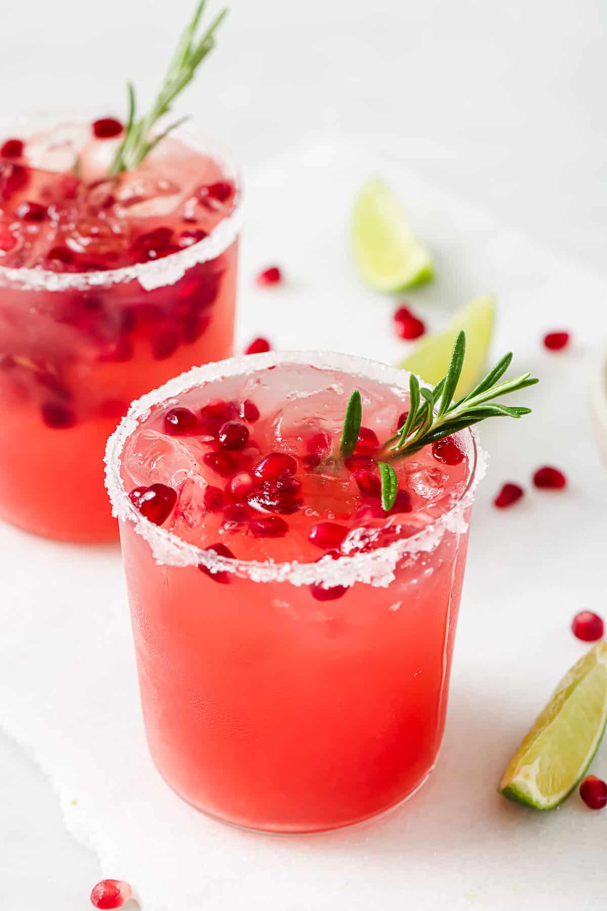 Two pomegranate cocktails with rosemary.