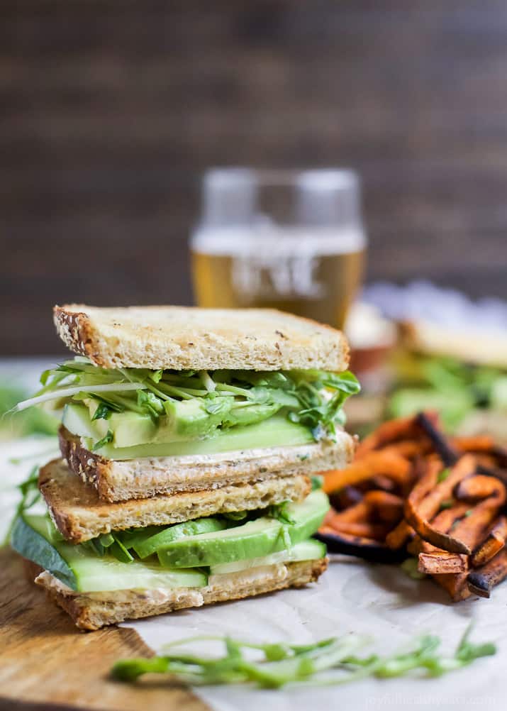 Two halves of Cucumber Avocado Sandwich stacked next to sweet potato fries