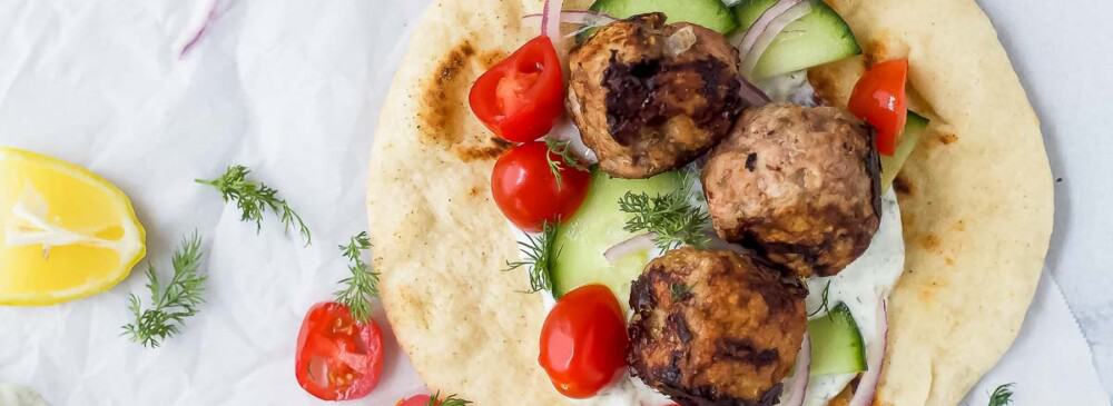Overhead view of greek turkey meatball gyros with tomatoes and cucumber