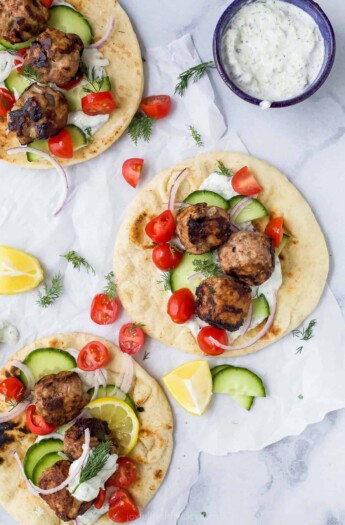 Overhead view of greek turkey meatball gyros with tomatoes and cucumber