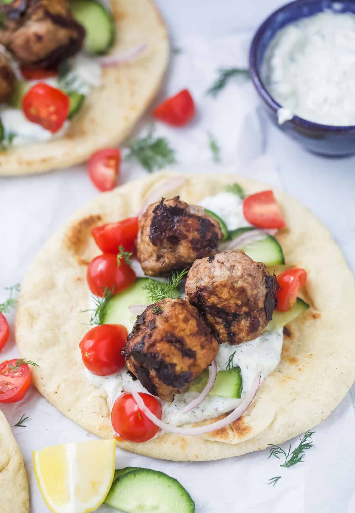 Angled view of a Greek turkey meatball gyro with tzatziki