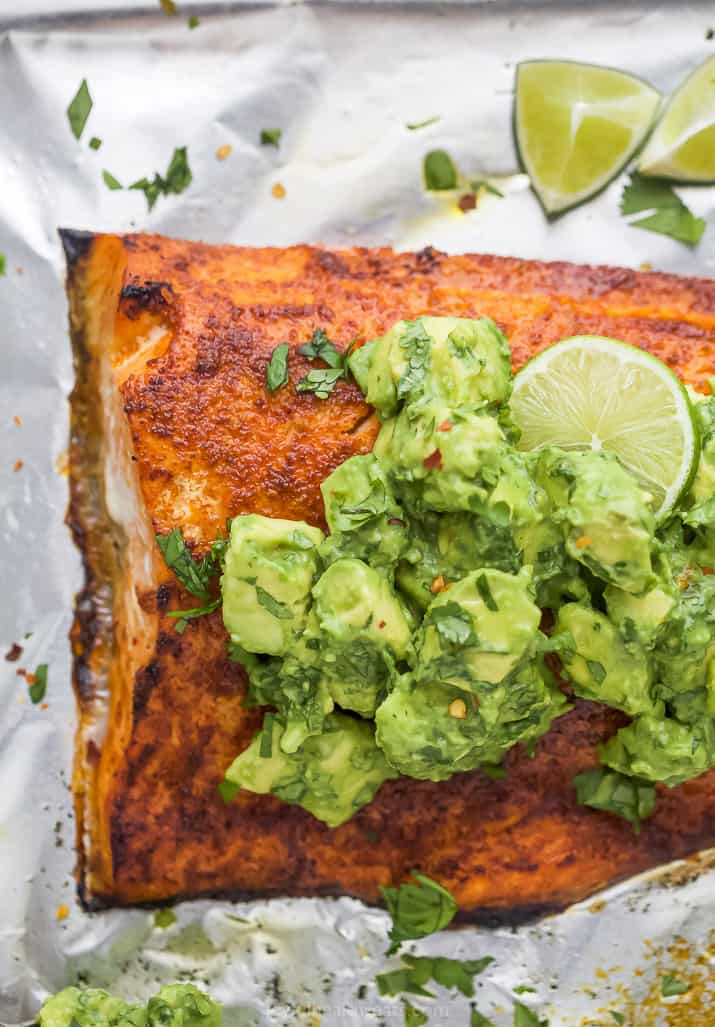 Spice rub oven baked salmon with avocado on top.