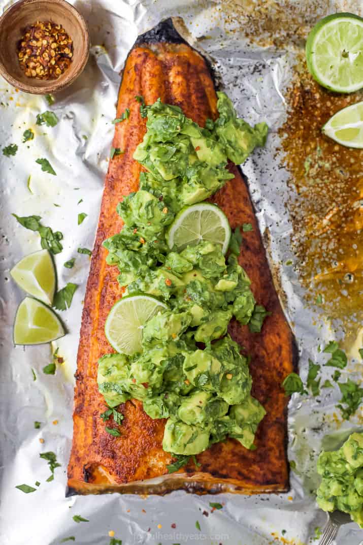 Spice rub baked salmon is seared in the oven for that perfect flaky bite, then topped with a creamy avocado salsa for the ultimate dinner! Baked salmon in foil with avocado salsa on top.