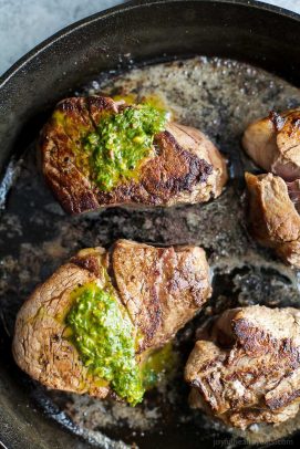 Top view of Filet Mignon in a skillet with chimichurri sauce