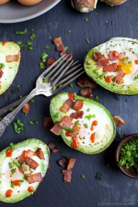 Baked avocado eggs topped with bacon, chives, and sriracha.