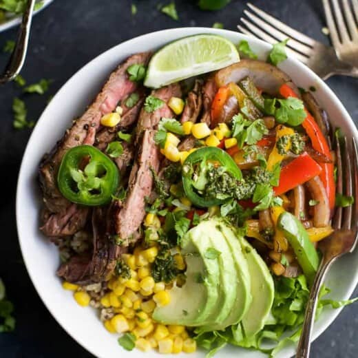 steak fajita burrito bowl filled with quinoa, fajita steak, avocado and a cilantro lime chimichurri sauce