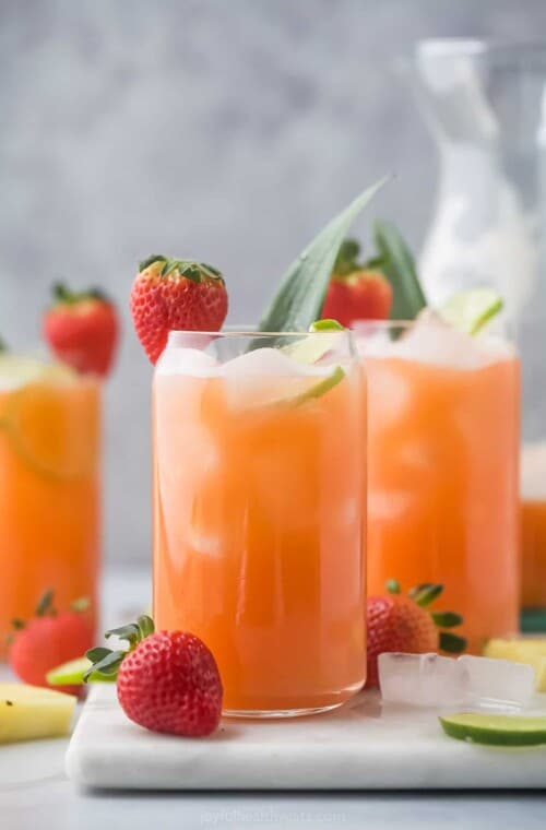 Angled view of three glasses of strawberry agua fresca