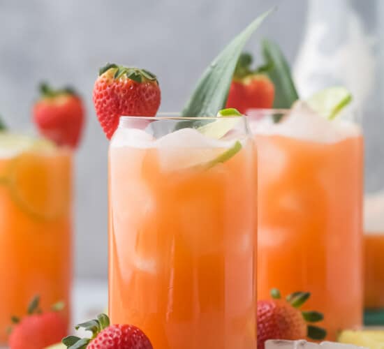 Angled view of three glasses of strawberry agua fresca