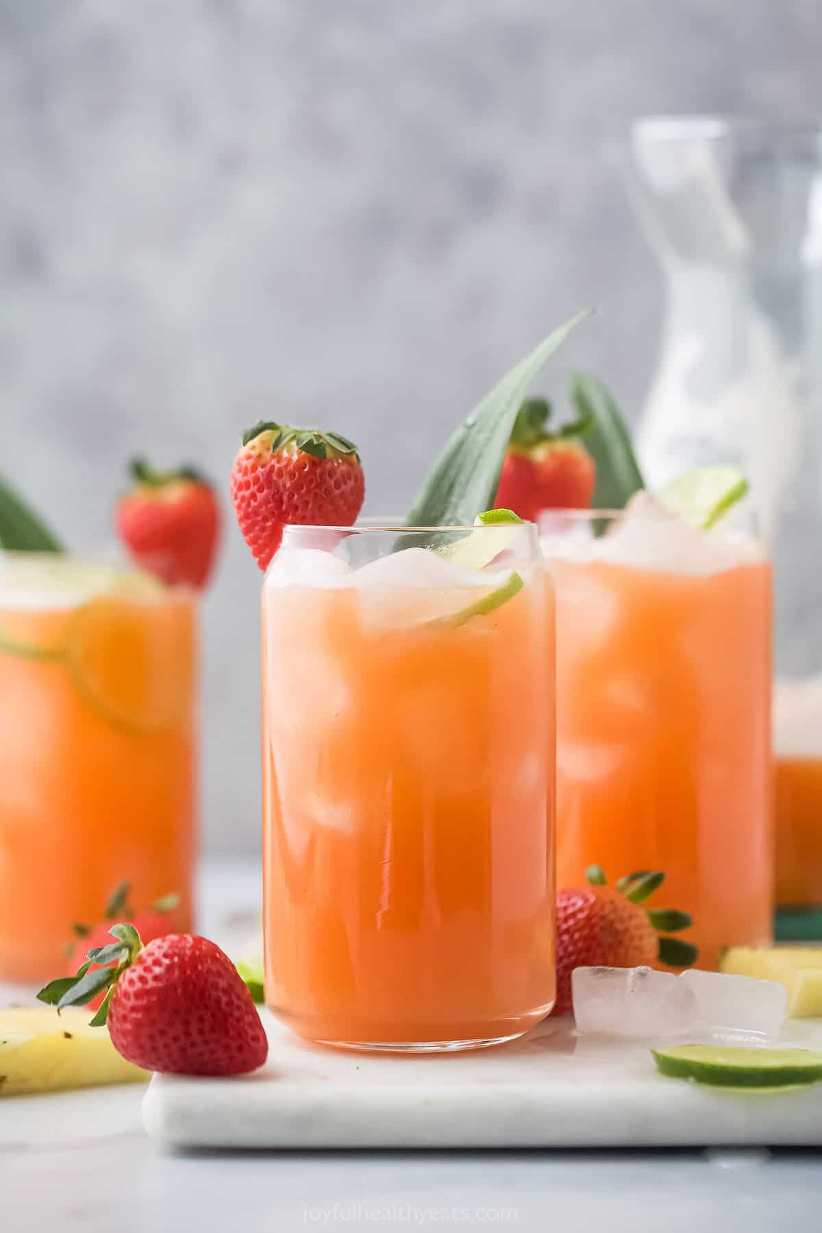 Angled view of glasses of pineapple strawberry agua fresca