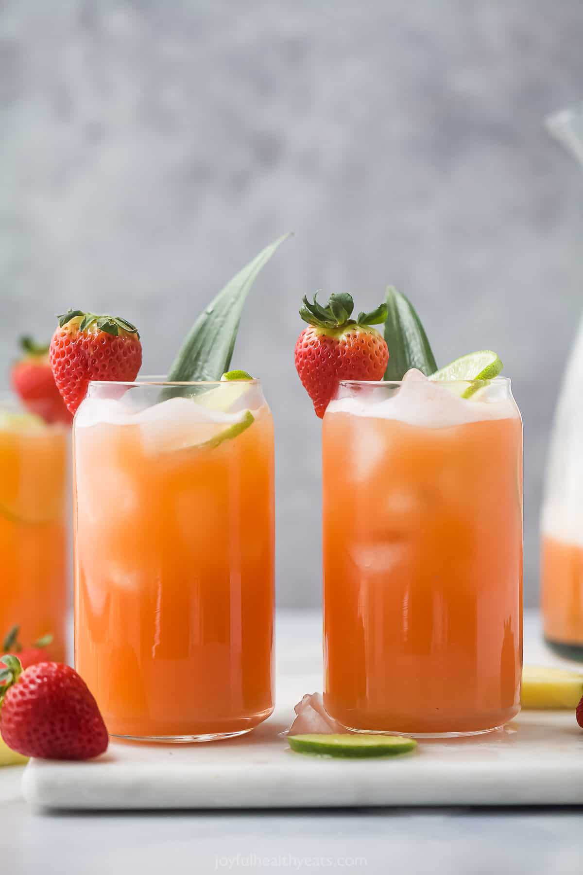 Front view of two glasses of pineapple strawberry agua fresca