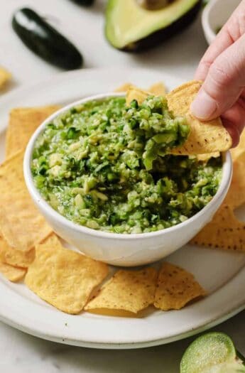 Dipping a tortilla chip into Mexican salsa verde.