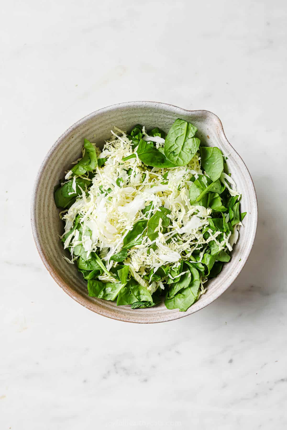 Mixing the cabbage and spinach. 