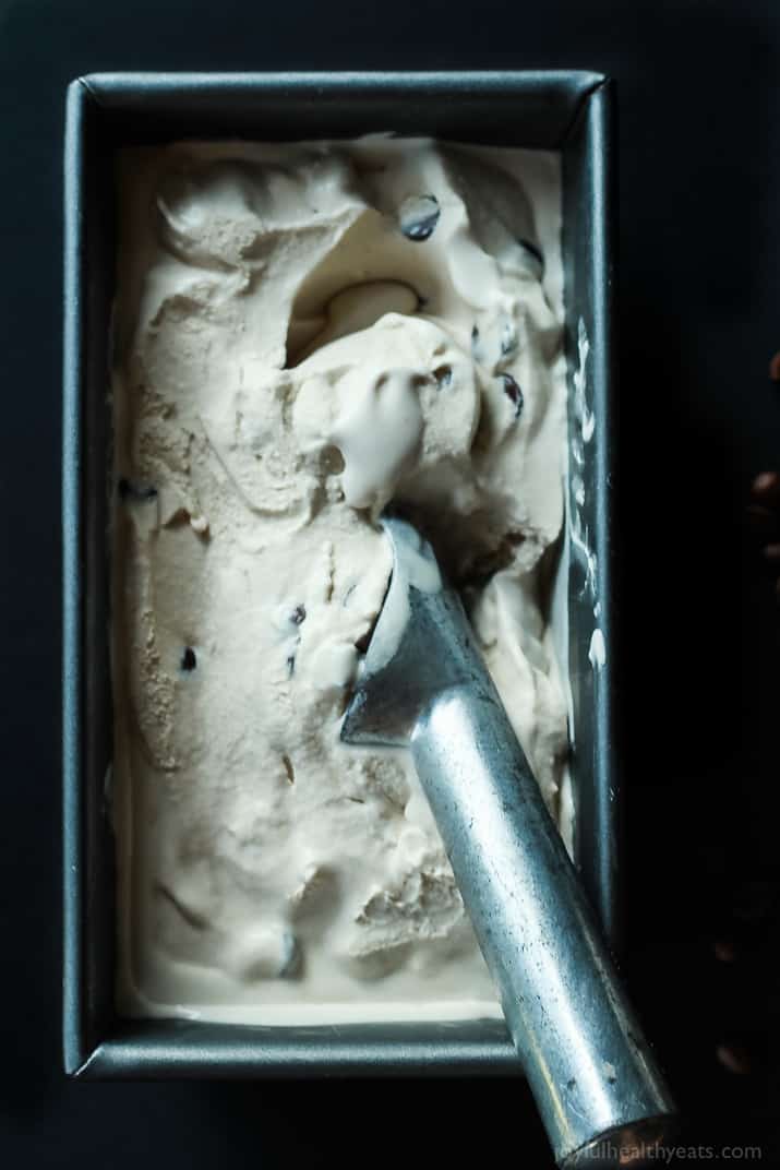 A Container of Homemade Espresso Ice Cream with a Metal Scooper Inside