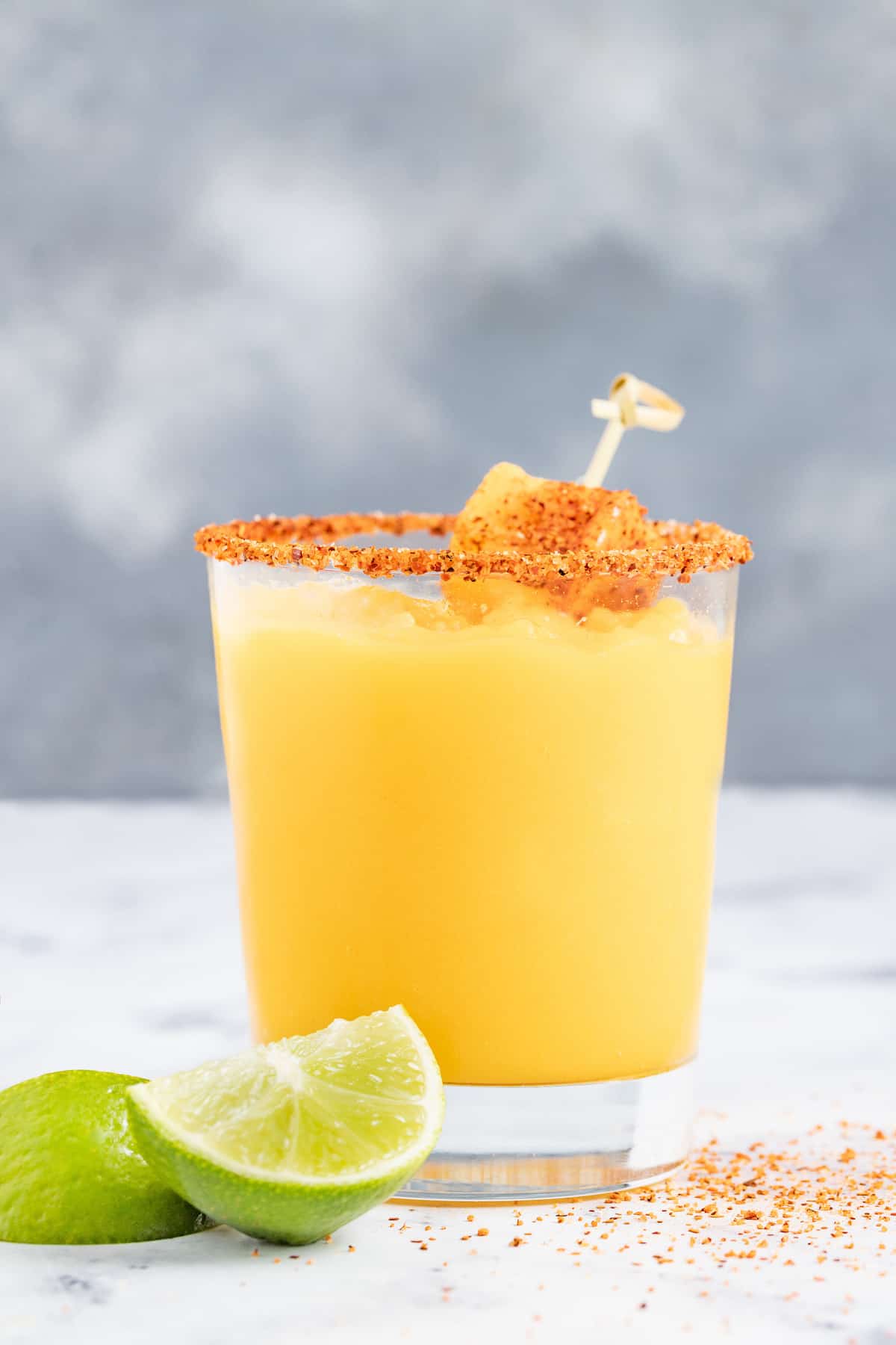 Served in chili-rimmed glasses, this frozen mango margarita is the boozy, tropical drink you need to beat the heat this summer. Side shot of mango margarita.