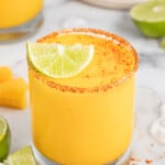 Frozen mango margarita with a lime wedge.