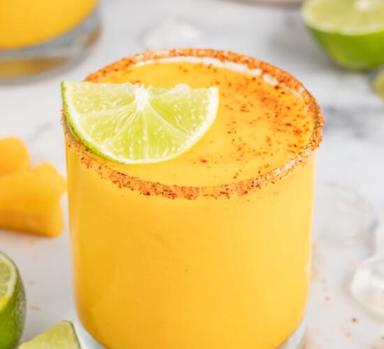 Frozen mango margarita with a lime wedge.