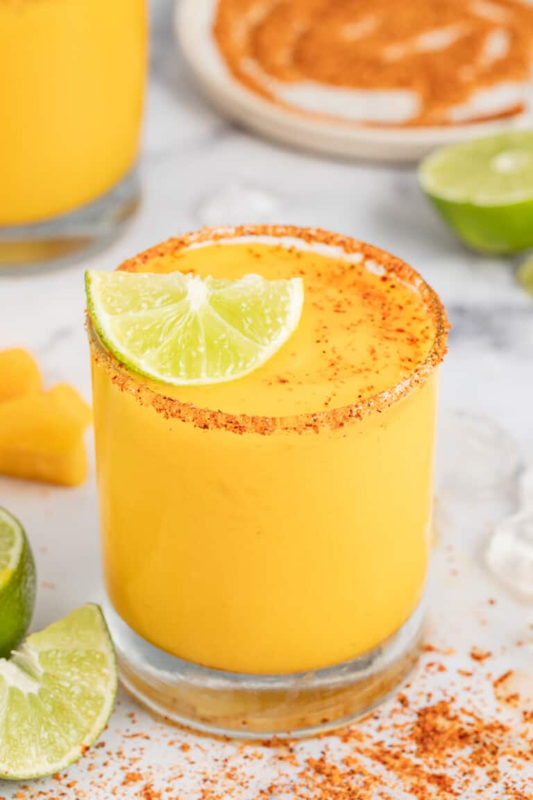 Frozen mango margarita with a lime wedge.