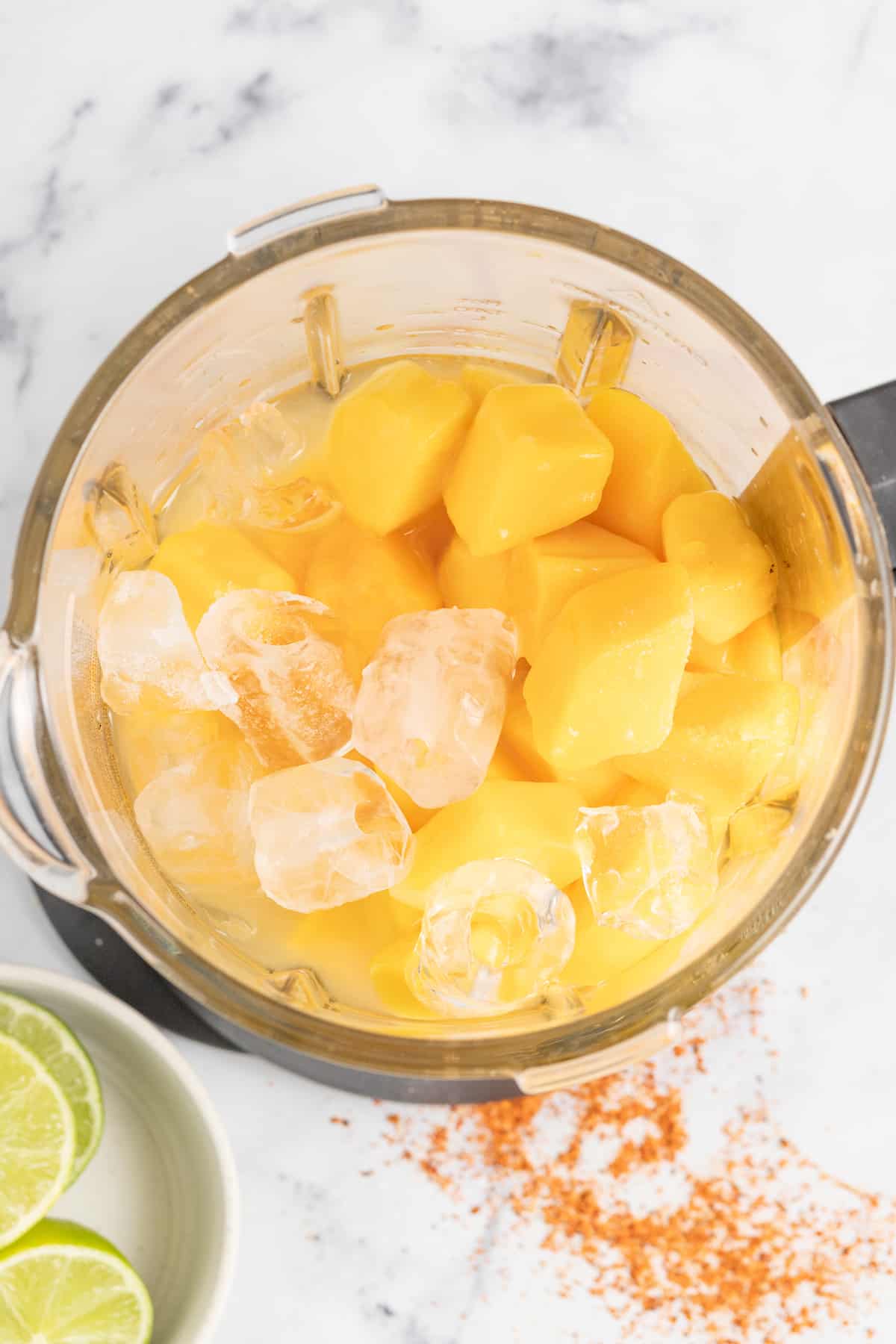 Served in chili-rimmed glasses, this frozen mango margarita is the boozy, tropical drink you need to beat the heat this summer. Adding the ingredients to the blender.