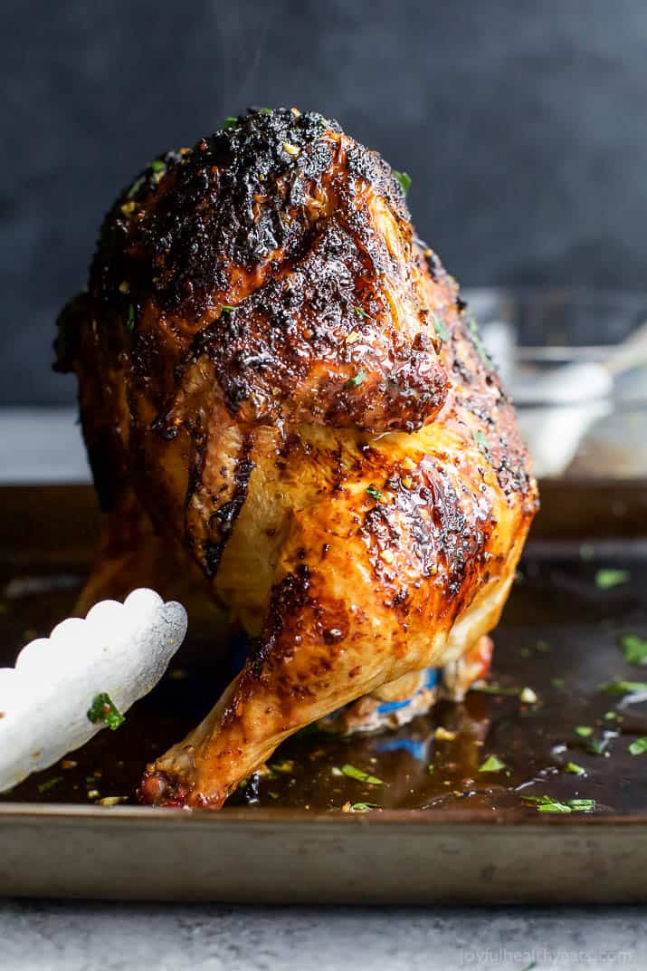 Glazed Honey Garlic Beer Can Chicken standing upright on a baking pan