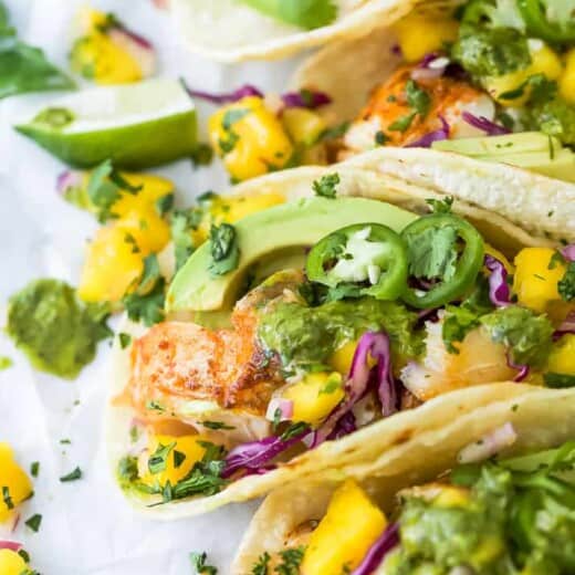 Close-up view of fish tacos with mango salsa, avocado and garnishes