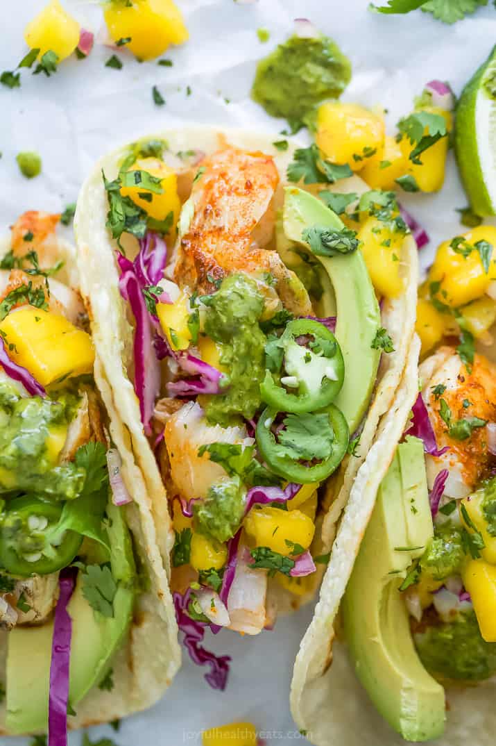 Close-up view of fish tacos with mango salsa, avocado and garnishes