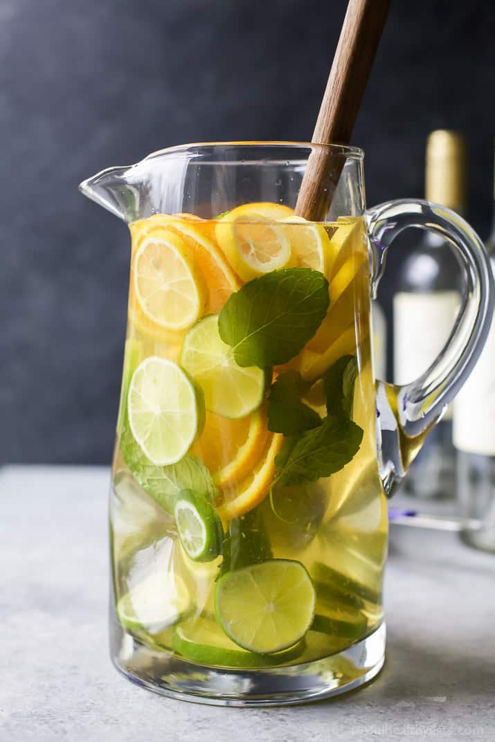 A pitcher of Citrus White Wine Sangria with sliced citrus fruit and fresh mint leaves