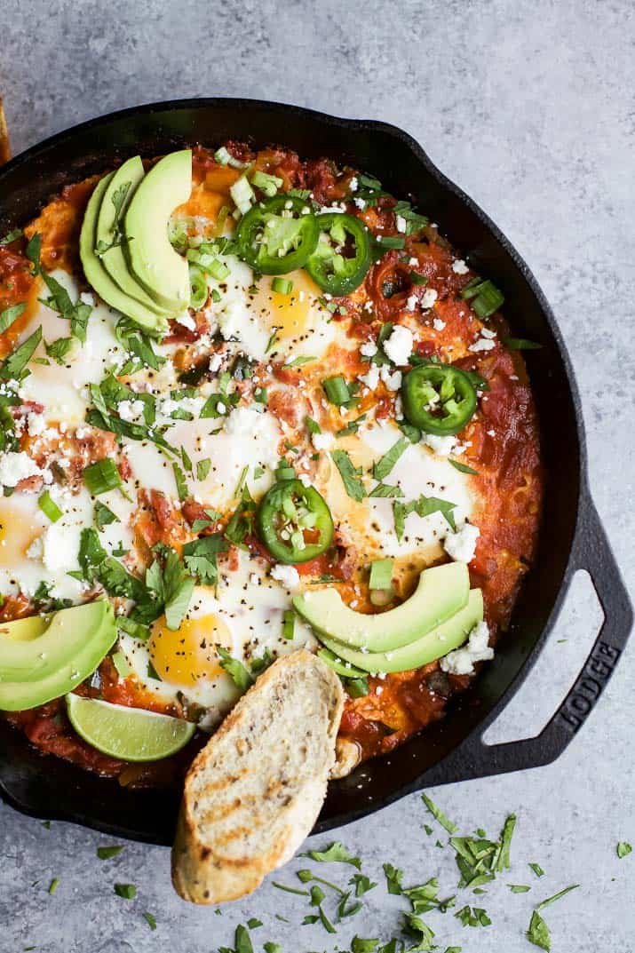 A skillet full of homemade shakshuka on a granite kitchen countertop