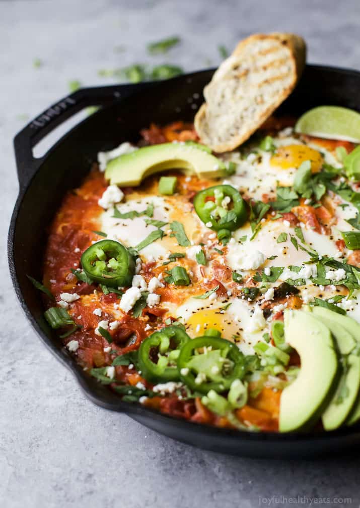 A skillet containing homemade Mexican shakshouka on top of a granite surface