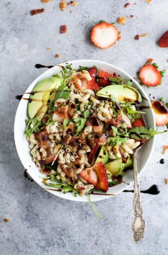 Easy Strawberry Avocado Pasta Salad tossed with fresh arugula, bacon, and a balsamic vinaigrette. The perfect pasta salad for those summer nights! | #ad | gluten free recipes