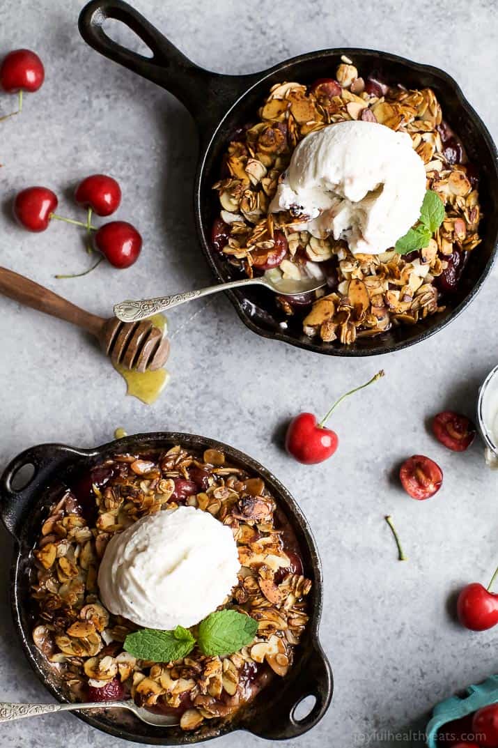 Top view of Cherry Crisp in two cast-iron pans with a scoop of vanilla ice cream