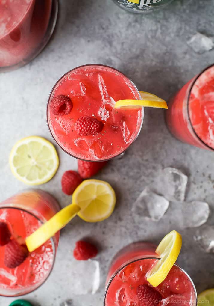 Top view of glasses of Chia Raspberry Lemonade Spritzer with fresh lemon and raspberry garnish