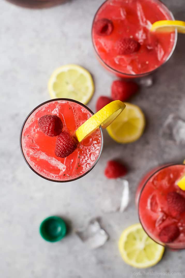 Top view of glasses of Chia Raspberry Lemonade Spritzer garnished with fresh raspberries and lemon slices