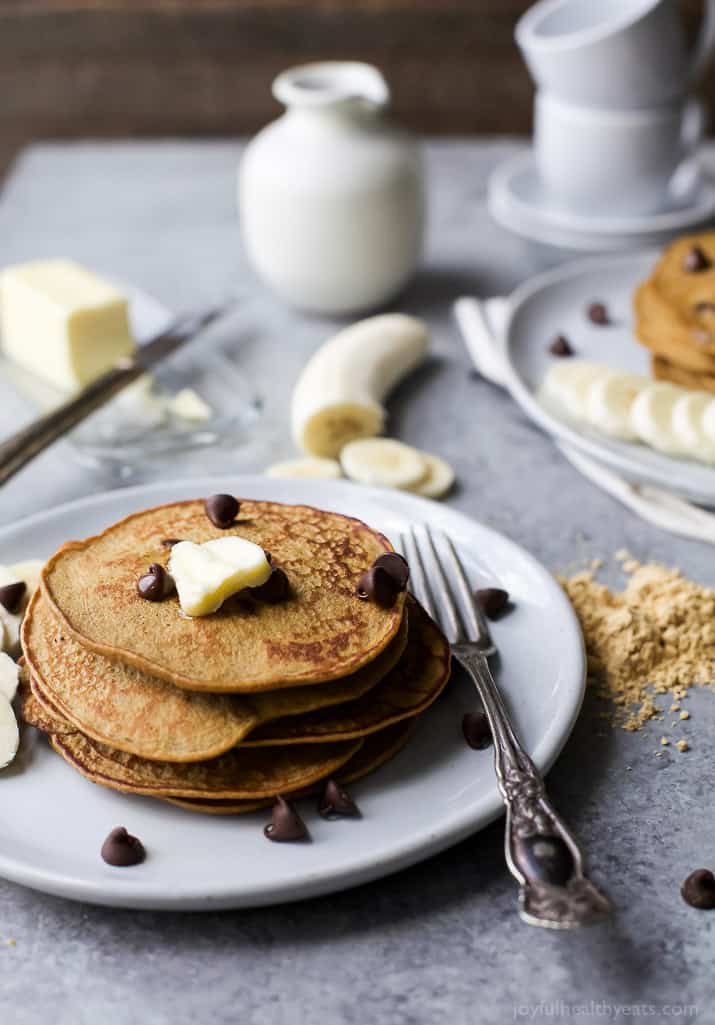 Flourless Peanut Chocolate Chip Pancakes A stack of Flourless Peanut Chocolate Chip Pancakes on a plate with a pat of butter on top