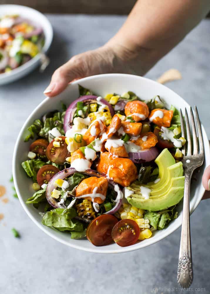 Grilled Buffalo Chicken Salad in a bowl with corn, red onion and sliced avocado
