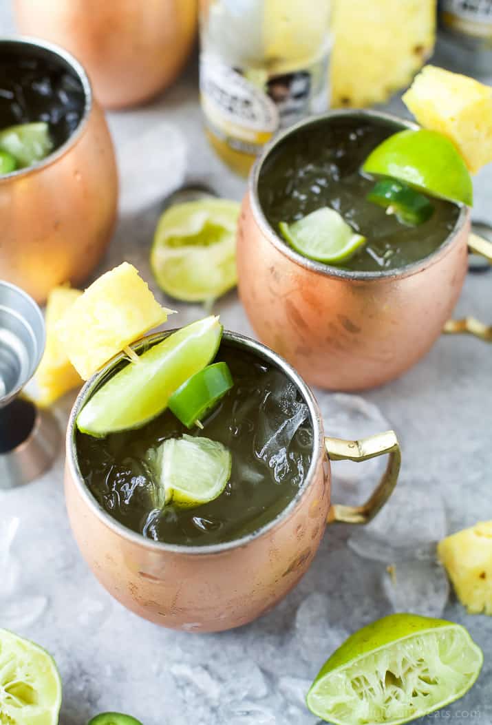 A Pineapple Moscow Mules topped with Jalapeno, lime and pineapple in copper cups