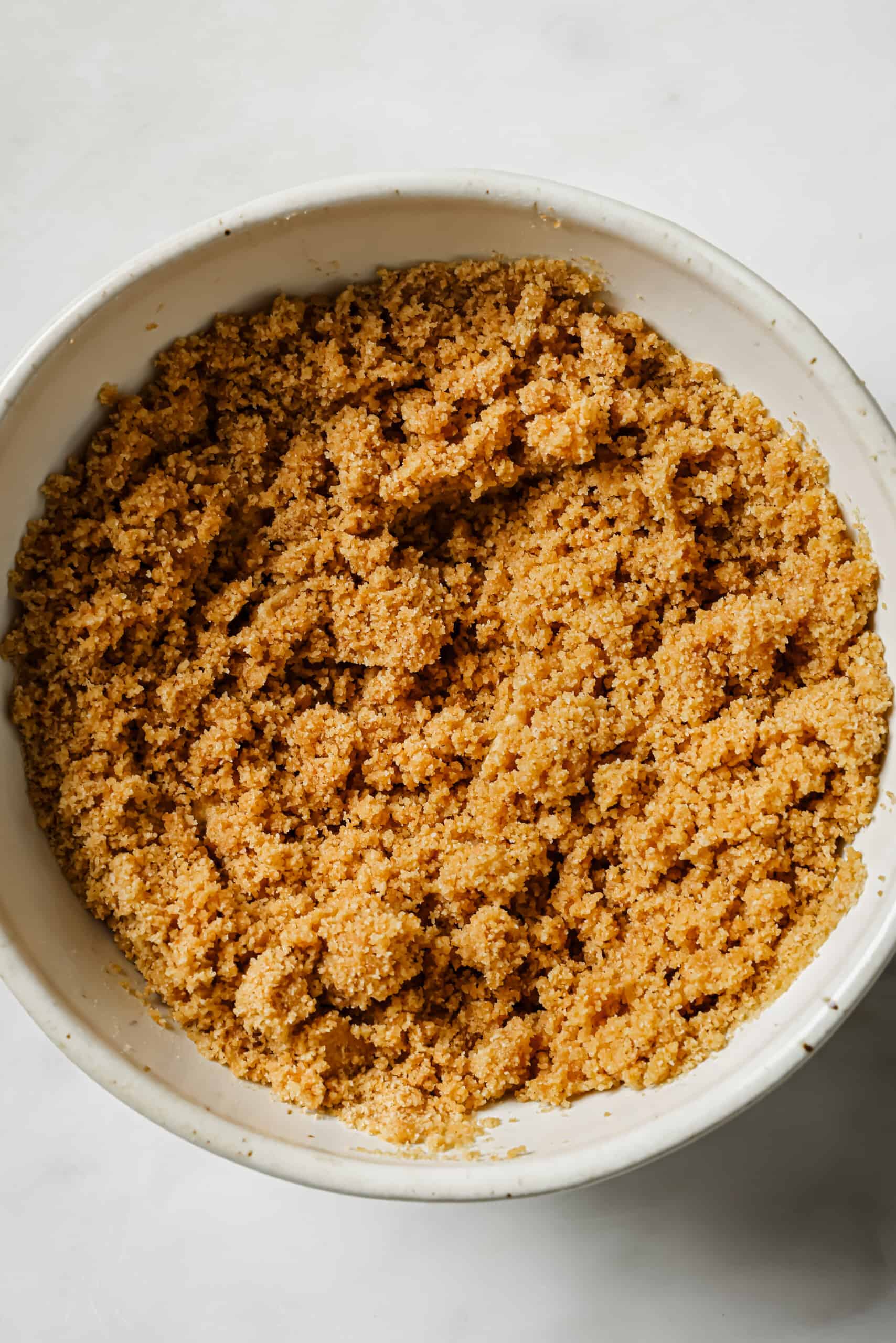 Blended graham cracker crust mixture mixed with butter.