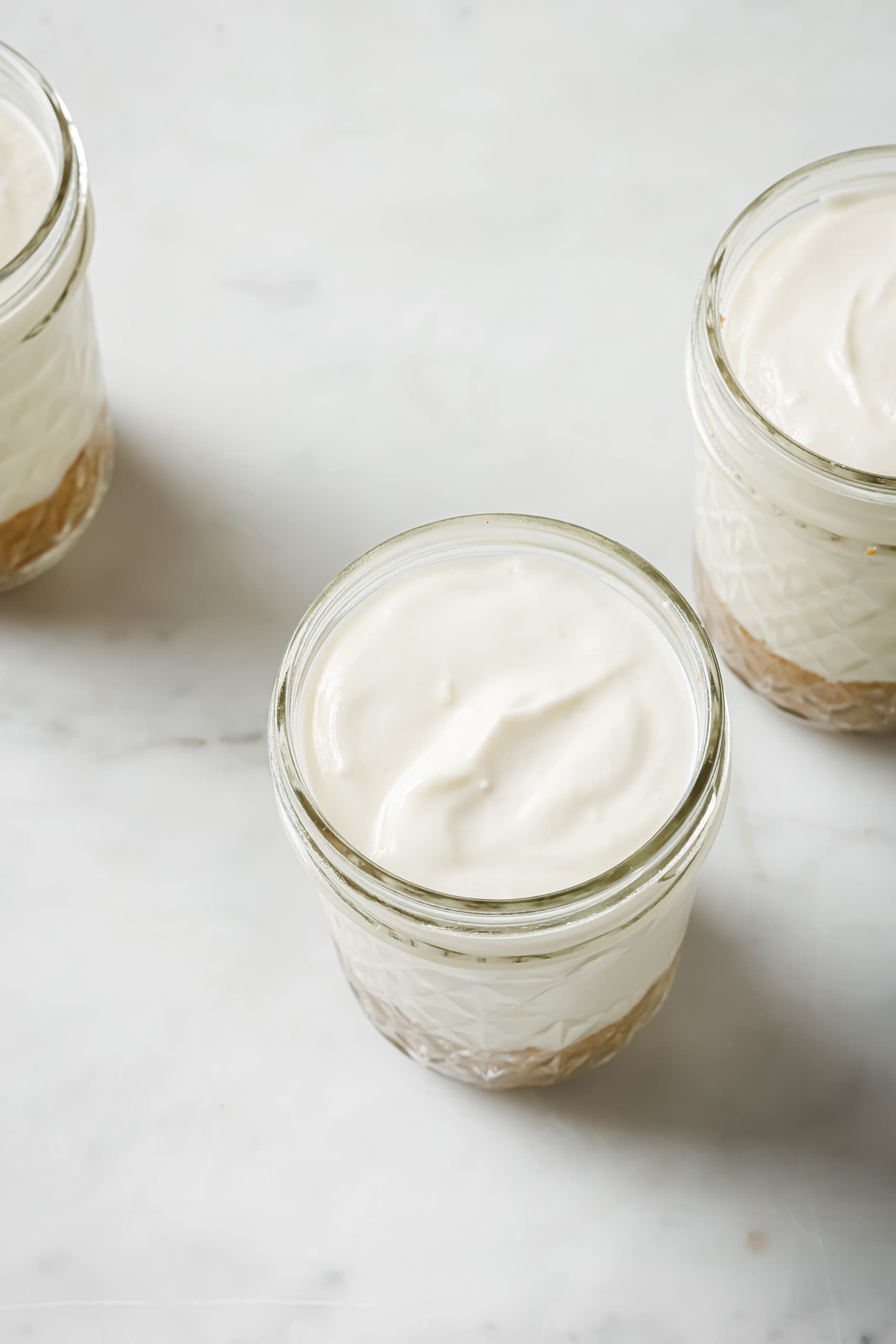 Filling the jars with cheesecake mixture and whipped cream. 