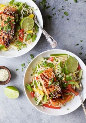 Two bowls of Easy Teriyaki Salmon served on a bed of Asian Noodles made with brown rice noodles, fresh veggies and a homemade Asian Sesame Dressing! | gluten free recipes