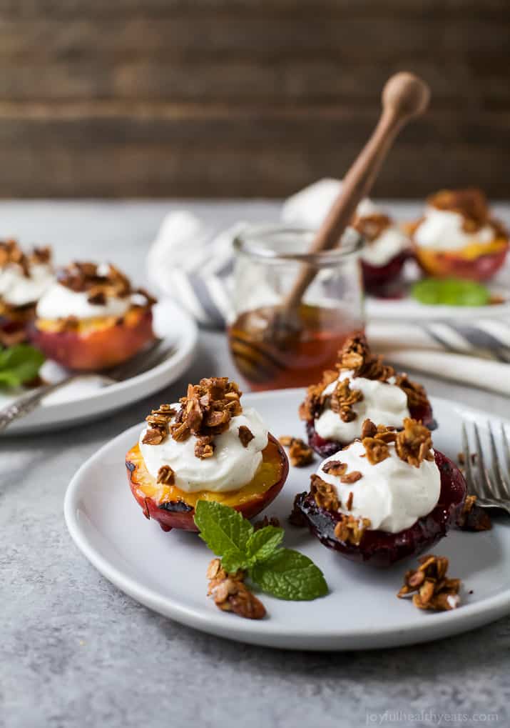 Grilled Stone Fruit topped with Vanilla Yogurt & Homemade Granola on a plate