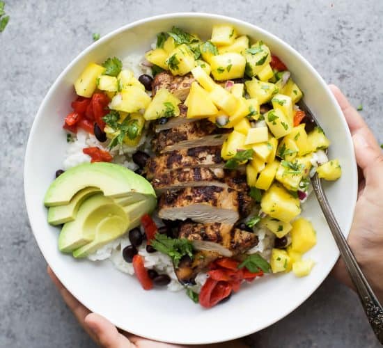Head to Jamaica with this Grilled Jerk Chicken Bowls topped with Mango Pineapple Salsa served over Coconut Rice. An easy gluten free weeknight meal your family will love! | #ad @justbarechicken