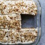 moist zucchini cake with cream cheese frosting in a baking dish