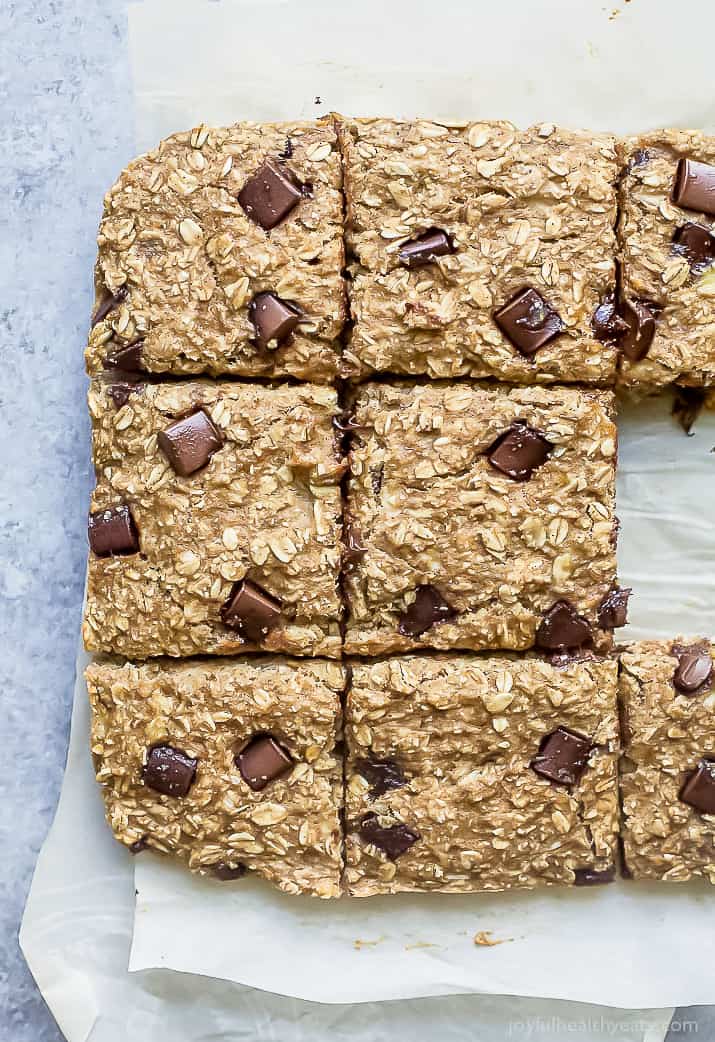 banana bread chocolate chip bars that have been cut up and laying on parchment paper on the countertop