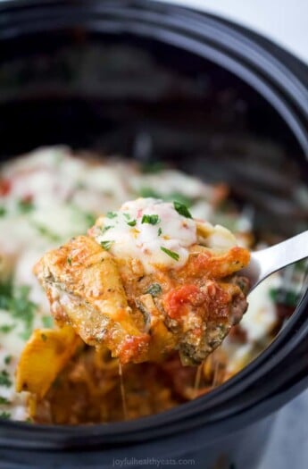 a spoon holding stuffed shells filled with ricotta and spinach