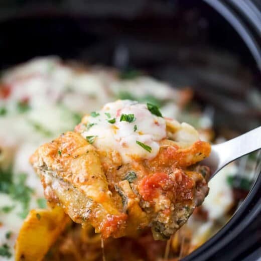 a spoon holding stuffed shells filled with ricotta and spinach