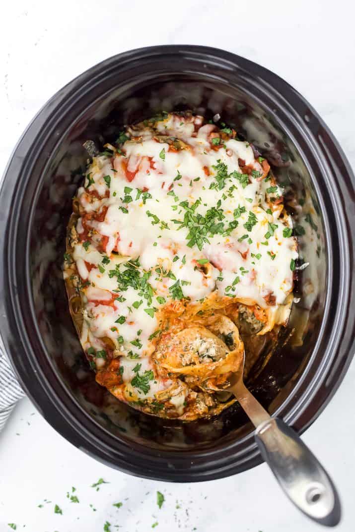 crock pot filled with stuffed shells and a spoon