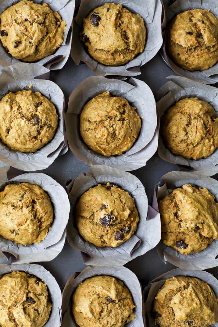 Top view of a dozen Healthy Carrot Cake Muffins in parchment wrappers