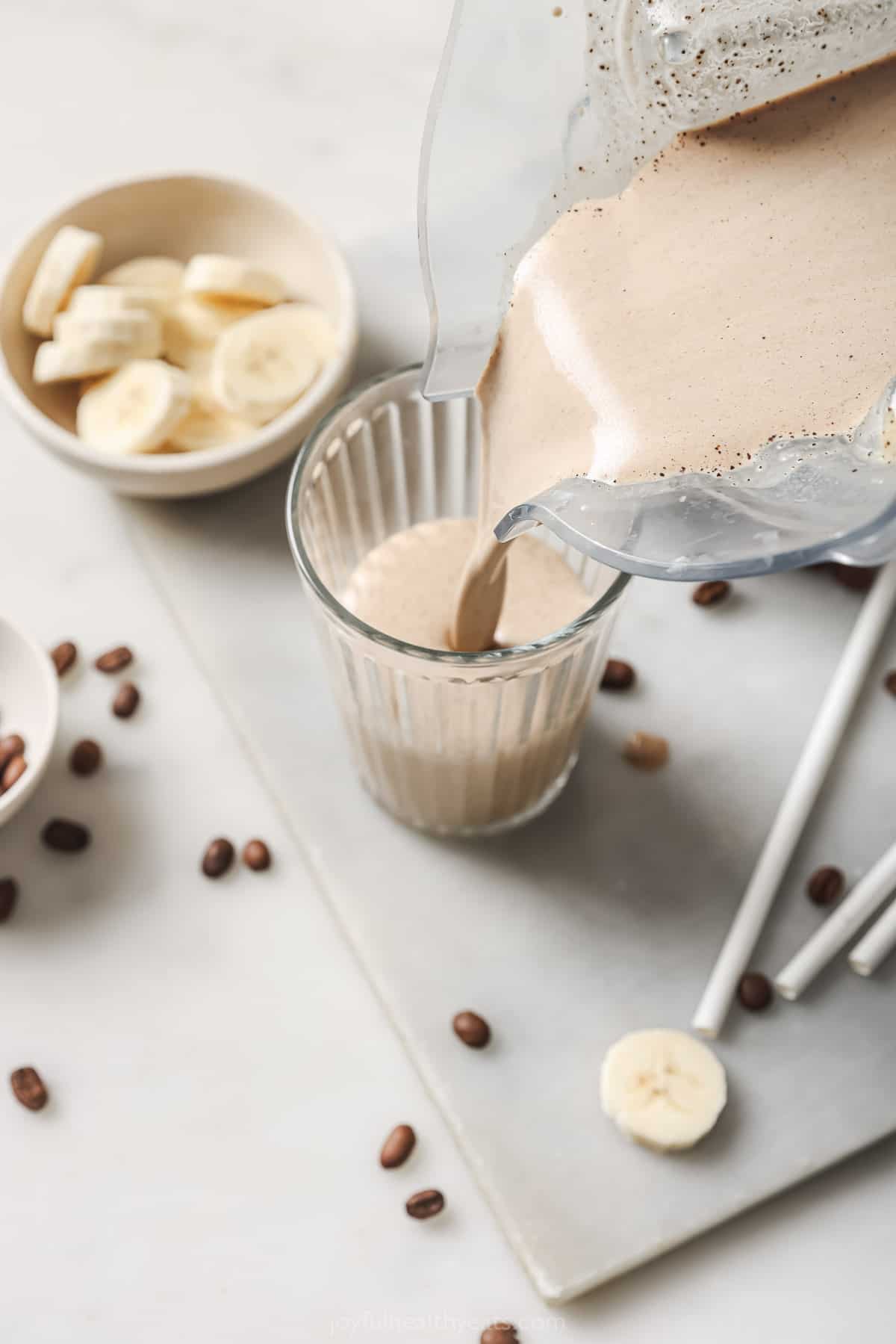 Pouring the coffee smoothie into a glass. 