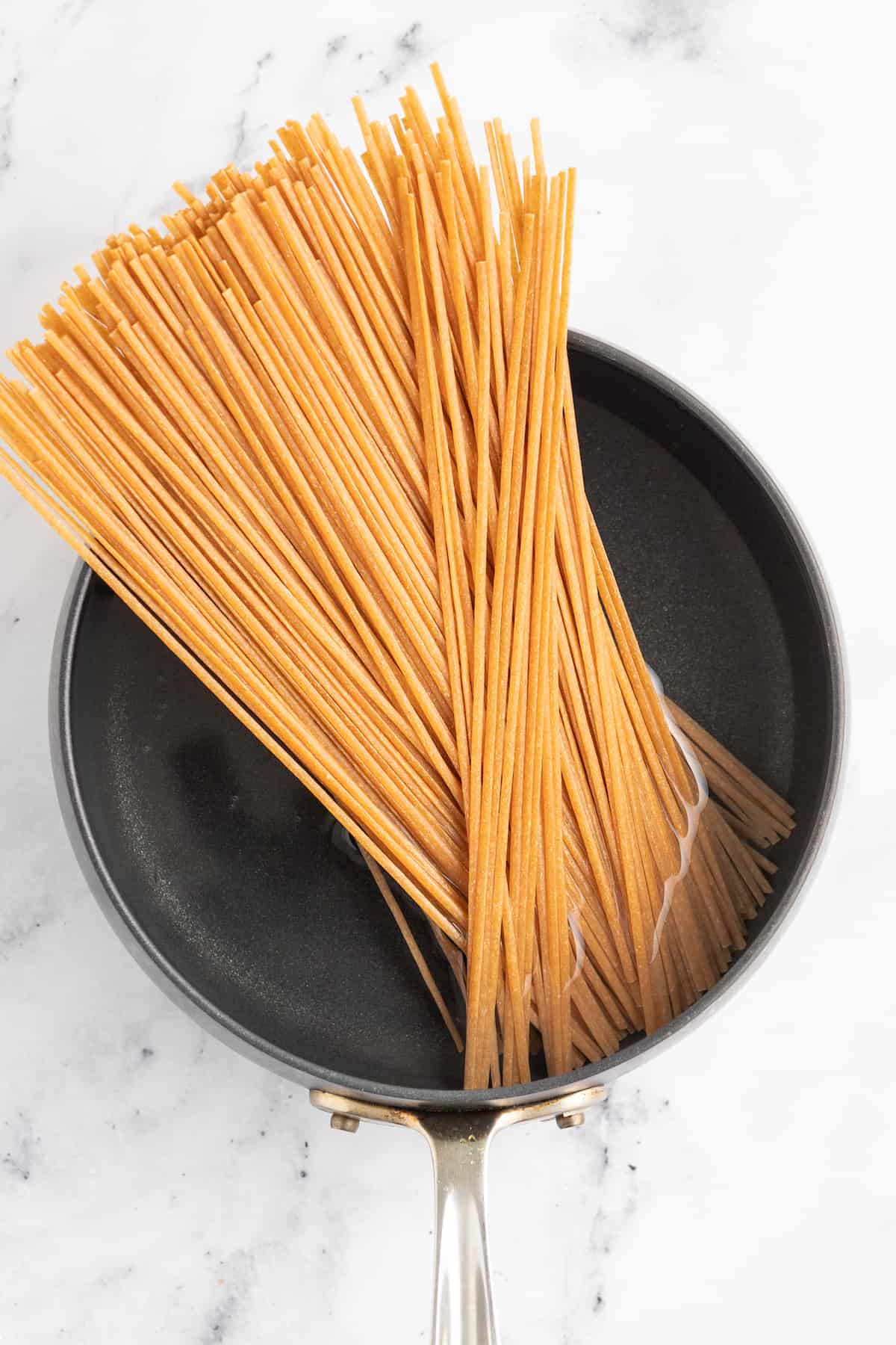 a pot with dried long noodles in it