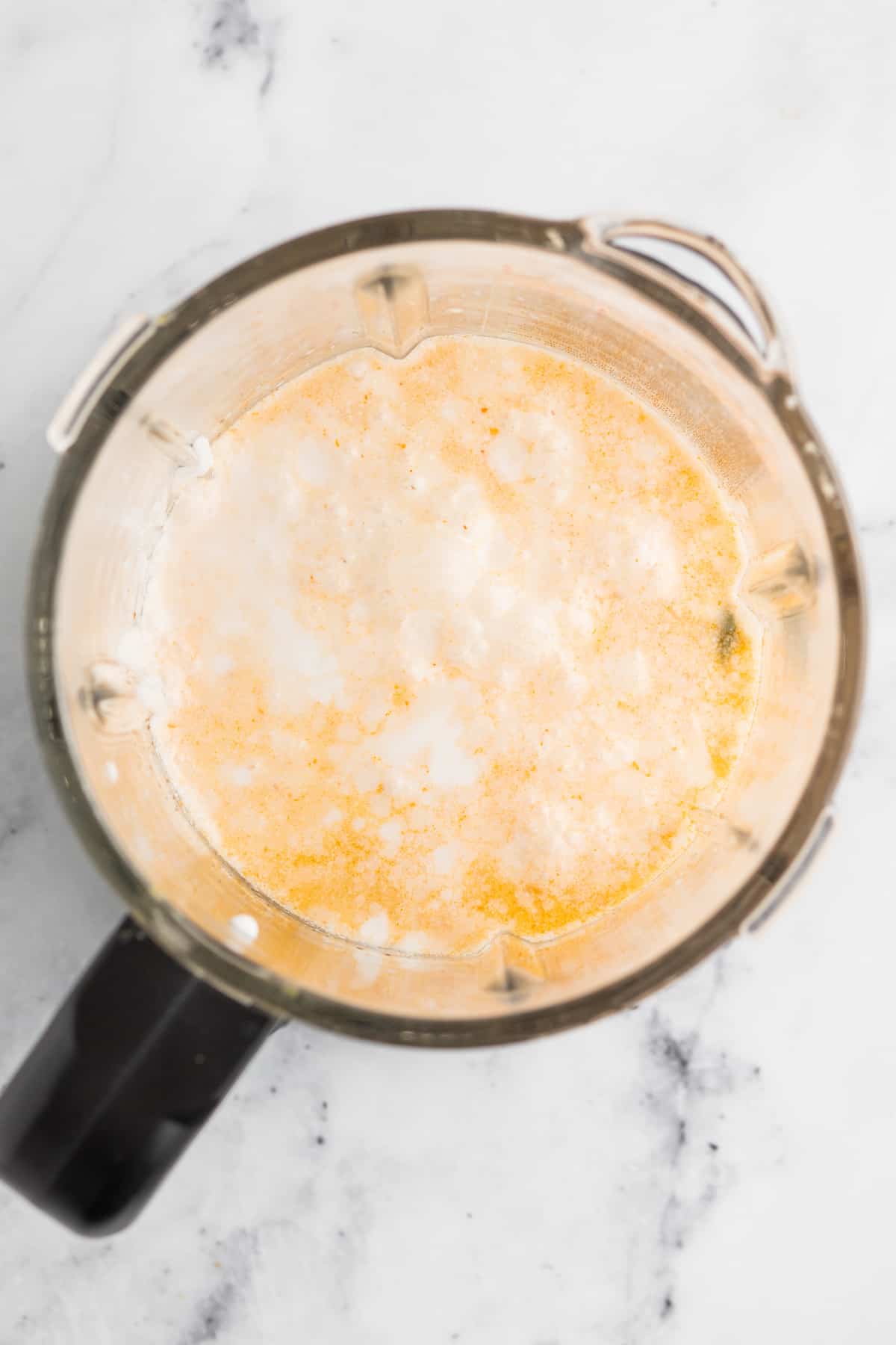 This easy Thai Chicken Noodle Soup is an epic homemade soup recipe that only takes 30 minutes to make. It's a simple and authentic recipe! a blender with a light orange cream mixture