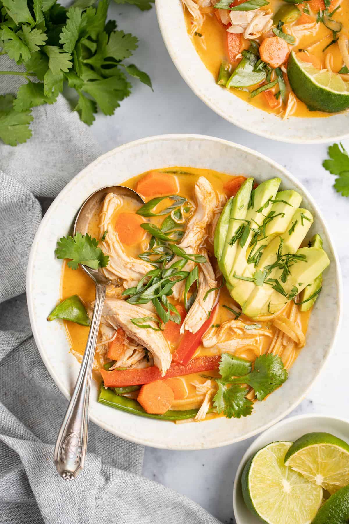 thai chicken noodle soup with avocado and fresh herbs